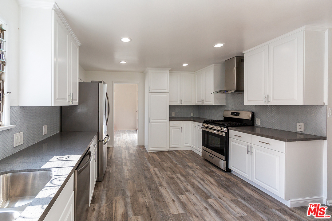 9428 Duxbury Road Los Angeles, CA 90034 - Photo 6 of 17 a kitchen with stainless steel appliances granite countertop a stove a sink and a refrigerator