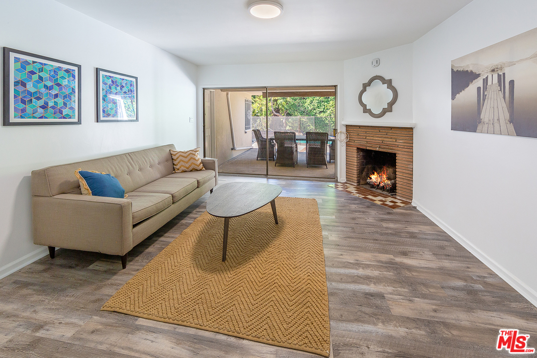 9428 Duxbury Road Los Angeles, CA 90034 - Photo 8 of 17 a living room with furniture a large window and a fireplace