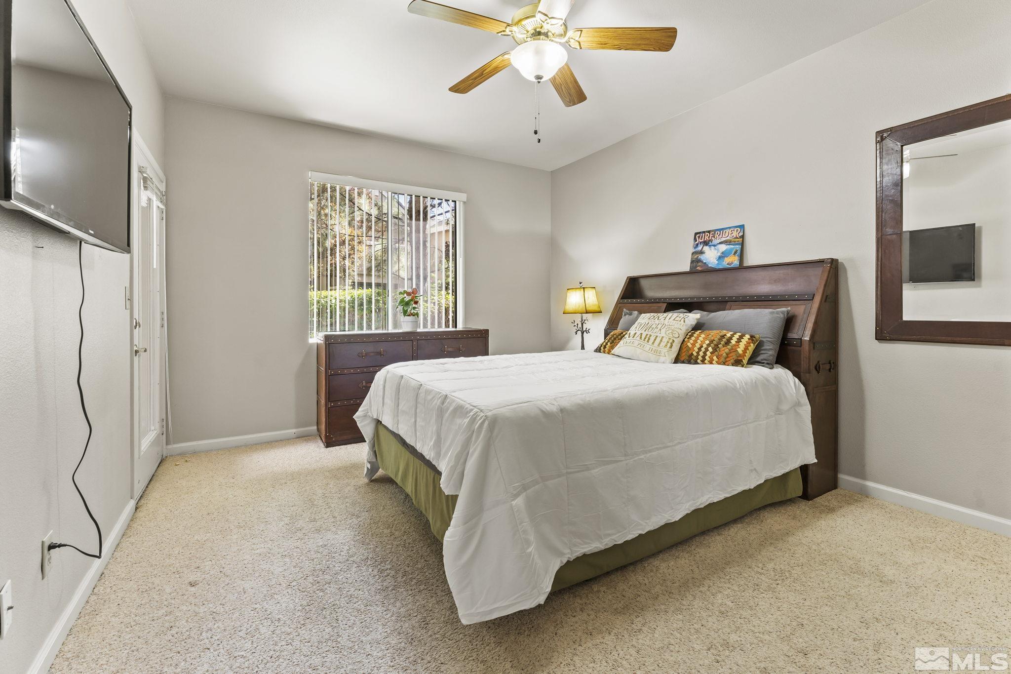 900 South Meadows Parkway, Unit 312 Reno, NV 89521 - Photo 18 of 38 a spacious bedroom with a bed and a chandelier