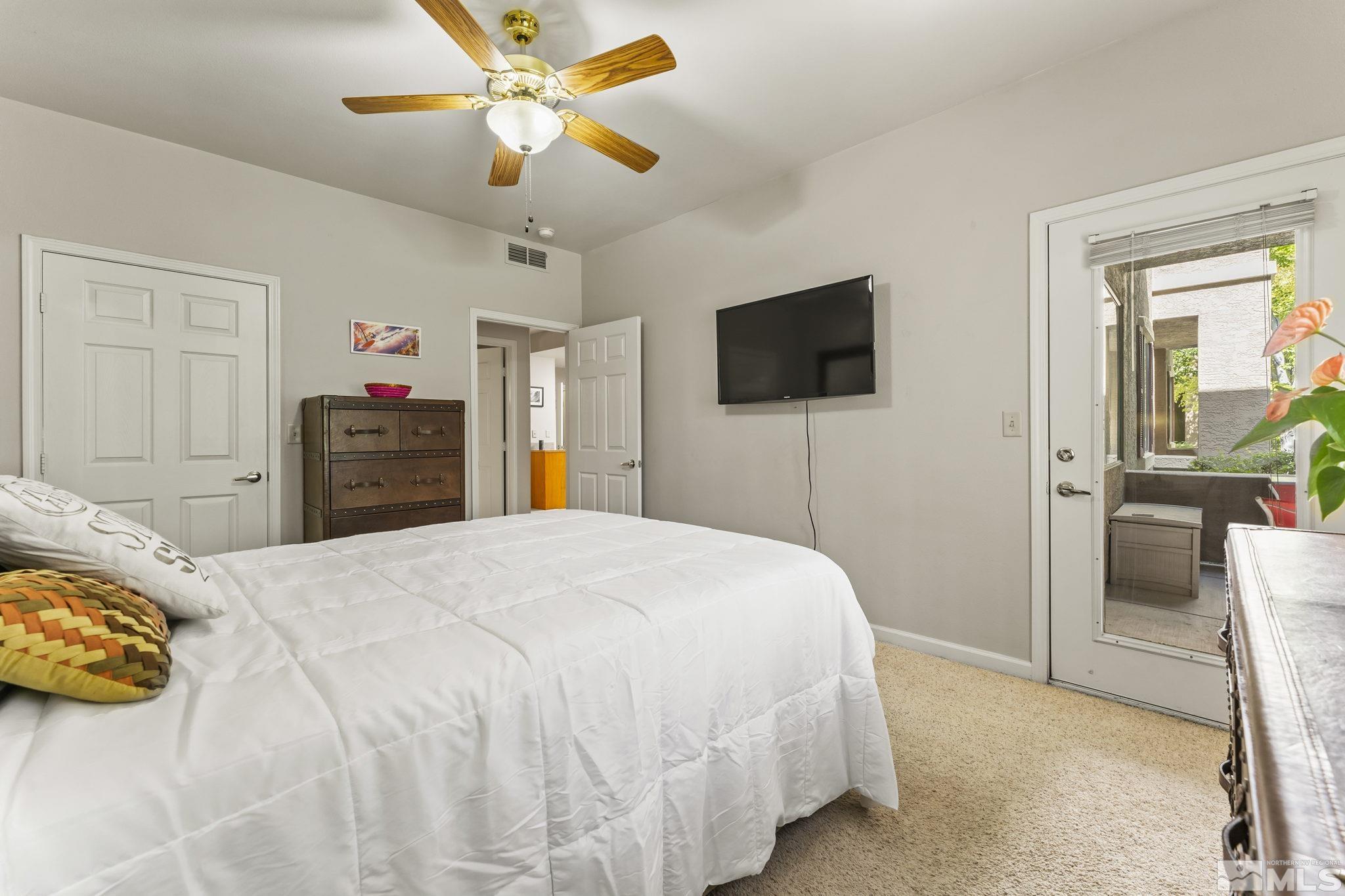 900 South Meadows Parkway, Unit 312 Reno, NV 89521 - Photo 19 of 38 a bedroom with a bed and a flat tv screen on dresser