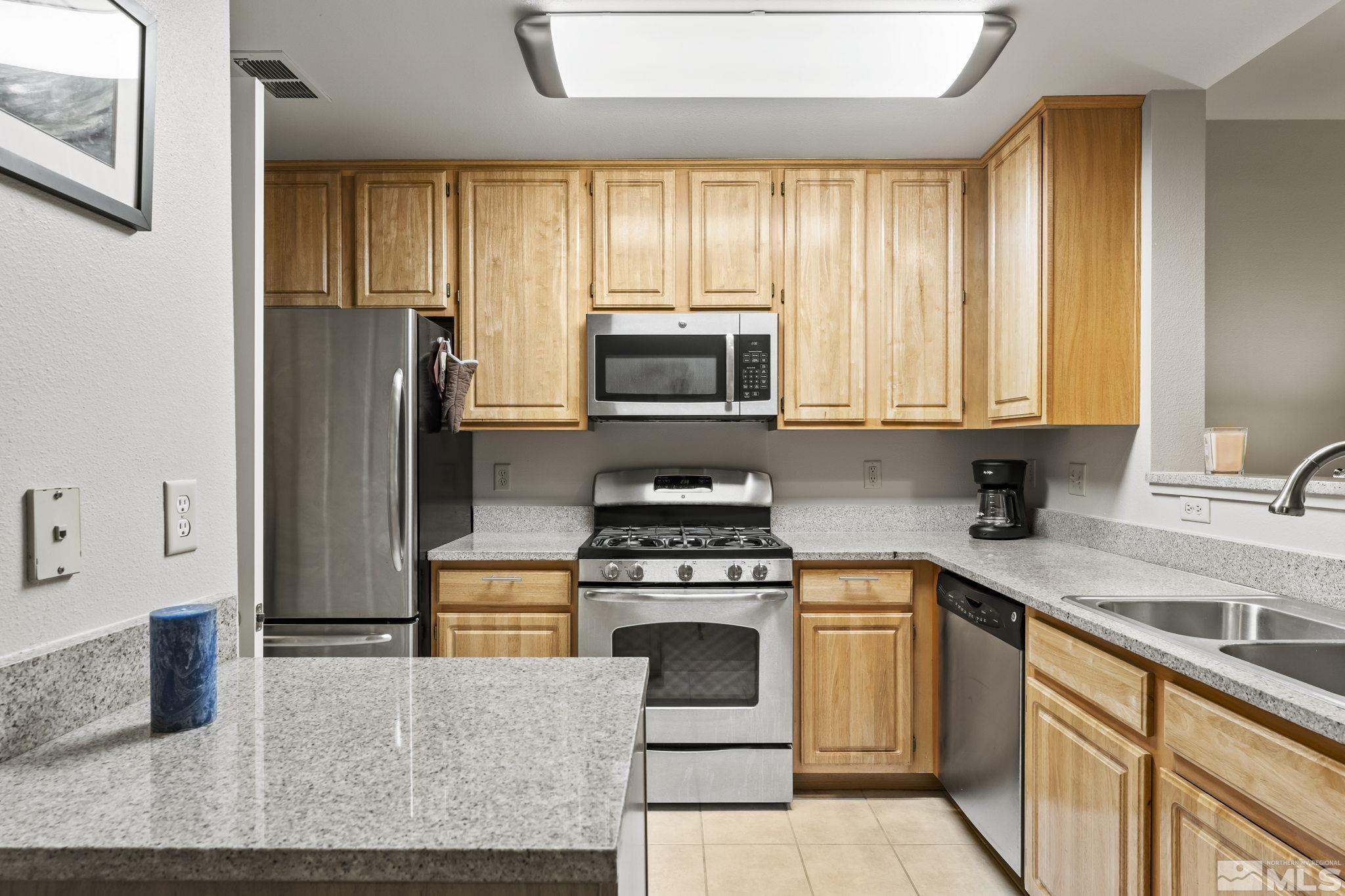 900 South Meadows Parkway, Unit 312 Reno, NV 89521 - Photo 6 of 38 a kitchen with a stove a sink and a microwave