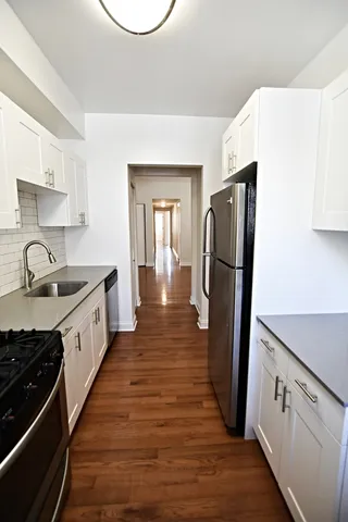 a kitchen with white cabinets and stainless steel appliances