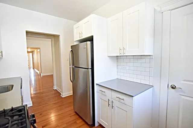 a kitchen with a refrigerator sink and cabinets