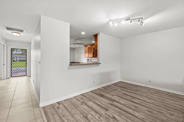 a view of a hallway with wooden floor and a bathroom