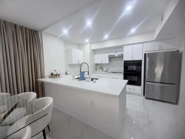a kitchen with refrigerator and chairs
