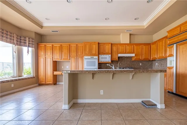 a kitchen with granite countertop a refrigerator and a sink