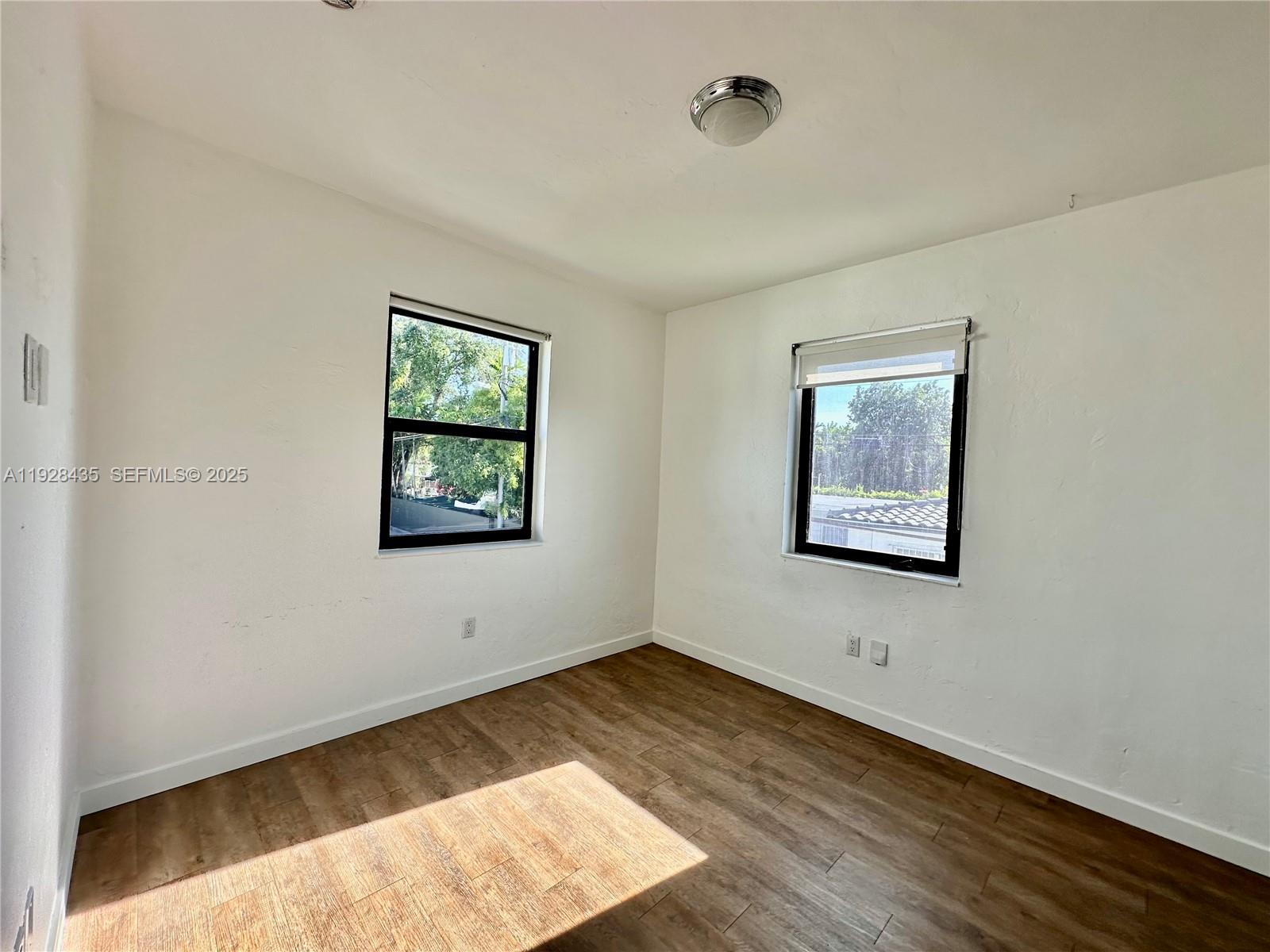4204 Southwest 14th Street, Unit 3 Miami, FL 33134 - Photo 12 of 12 a view of an empty room with wooden floor and a window