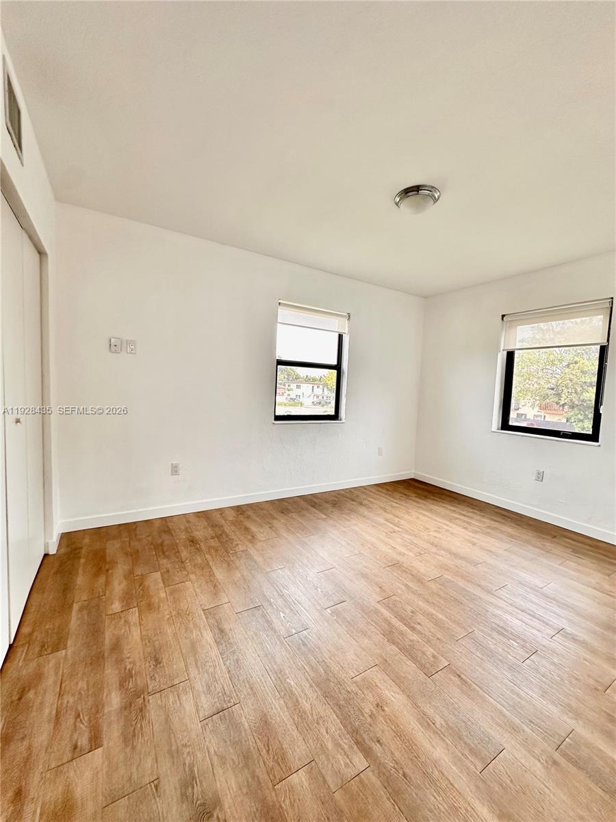 4204 Southwest 14th Street, Unit 3 Miami, FL 33134 - Photo 14 of 15 an empty room with wooden floor and windows