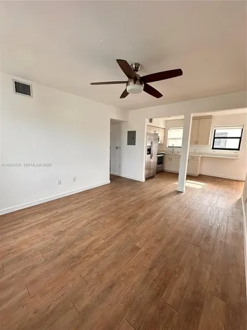 a view of a livingroom with wooden floor and a ceiling fan