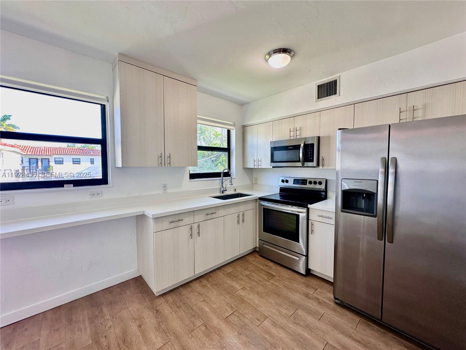 4204 Southwest 14th Street, Unit 3 Miami, FL 33134 - Photo 6 of 12 a kitchen with granite countertop a refrigerator and a sink