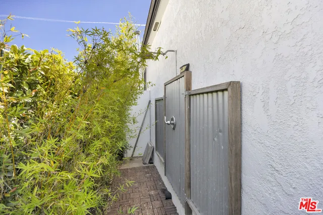 a view of a pathway of a house with potted plants