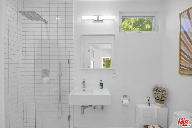 a bathroom with a sink a mirror and shower