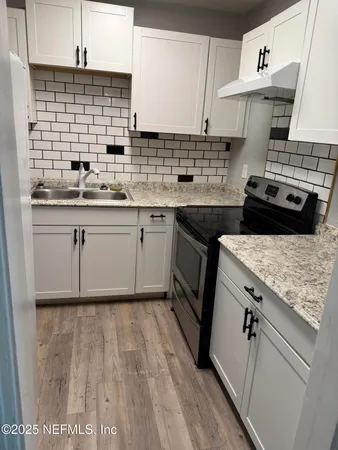 a kitchen with a sink stove and cabinets