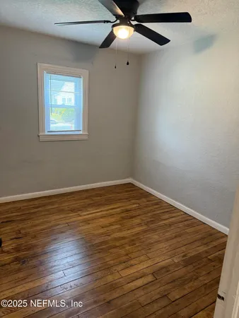 a view of an empty room with wooden floor