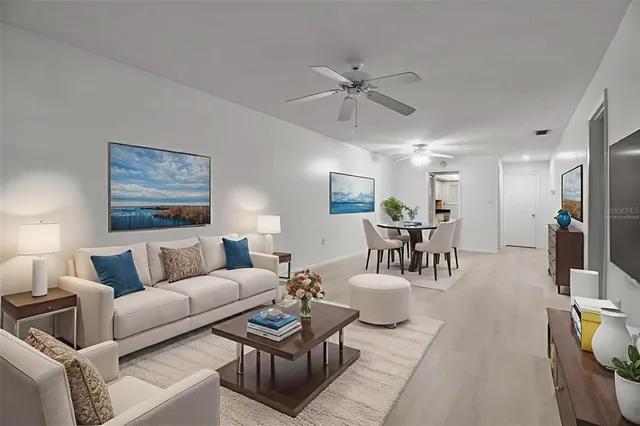 a living room with furniture and a view of kitchen