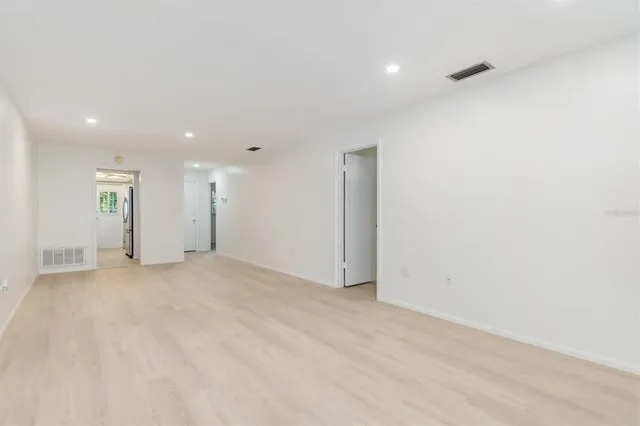 a view of an empty room with wooden floor