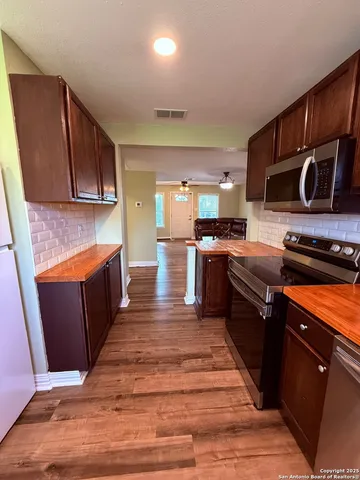 a kitchen with stainless steel appliances granite countertop a stove a sink and a microwave