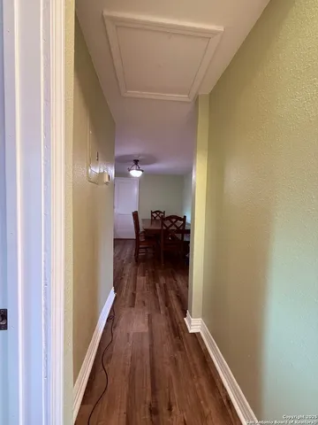 a view of a hallway with wooden floor