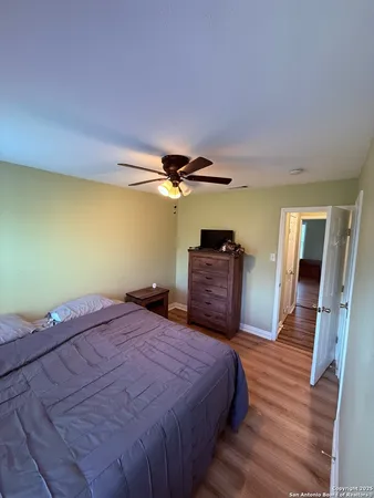 a bedroom with a bed dresser and a ceiling fan