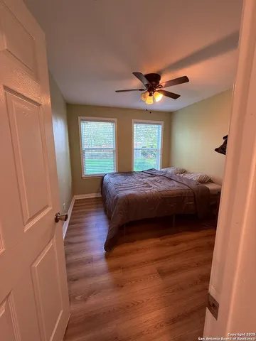 a bedroom with a bed and a ceiling fan