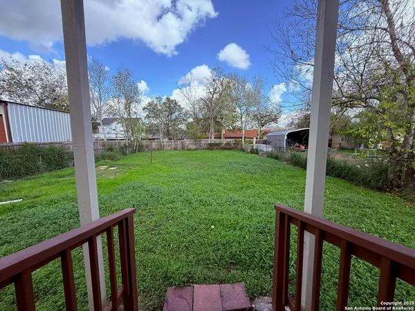 a view of a porch in a yard with large trees