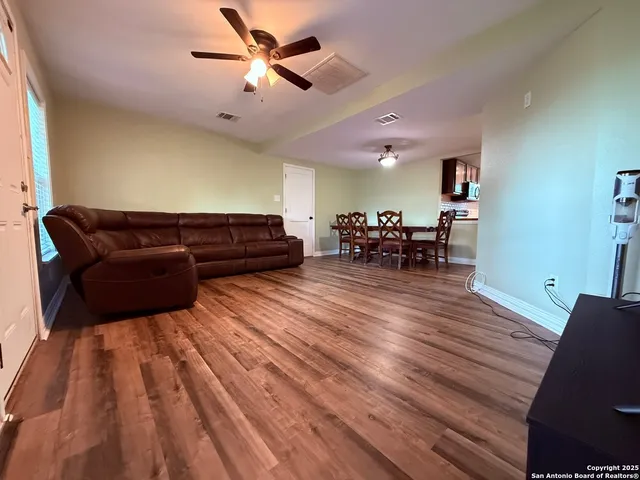 a living room with furniture and a wooden floor
