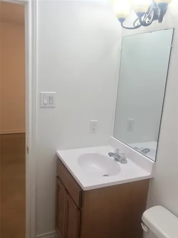 a bathroom with a sink and mirror with toilet