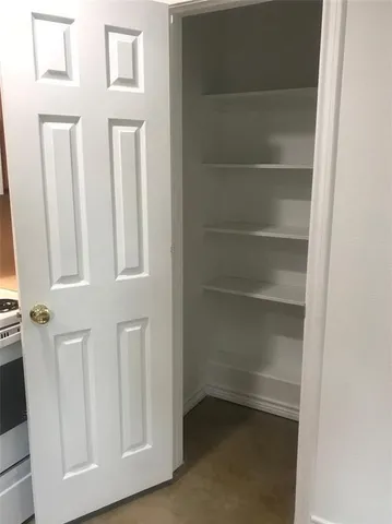 a view of walk in closet with empty racks