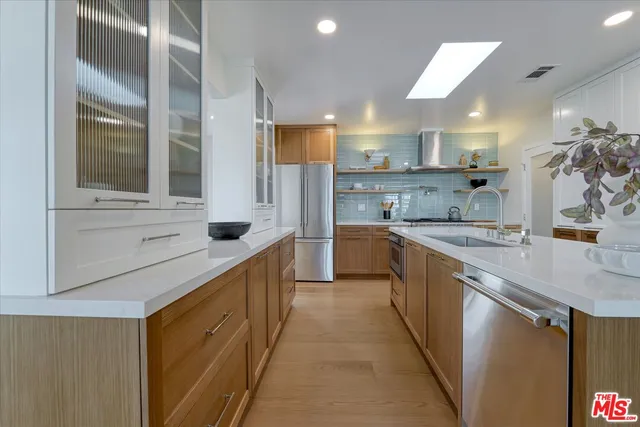 a large kitchen with stainless steel appliances lots of counter space and a sink