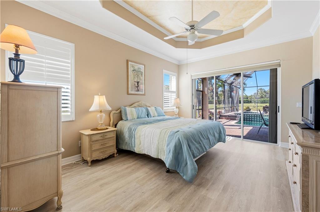 1411 Princess Sabal Point Naples, FL 34119 - Photo 11 of 32 Bedroom featuring ornamental molding, light wood-style floors, access to outside, a tray ceiling, and a ceiling fan