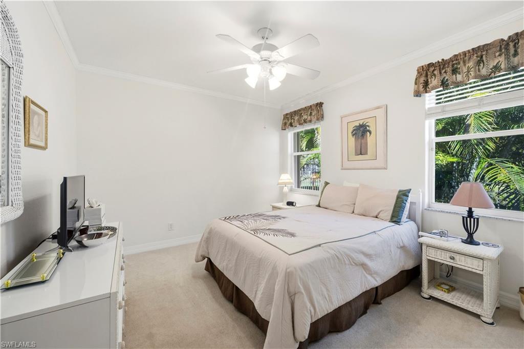 1411 Princess Sabal Point Naples, FL 34119 - Photo 13 of 30 a bedroom with a bed and a chandelier