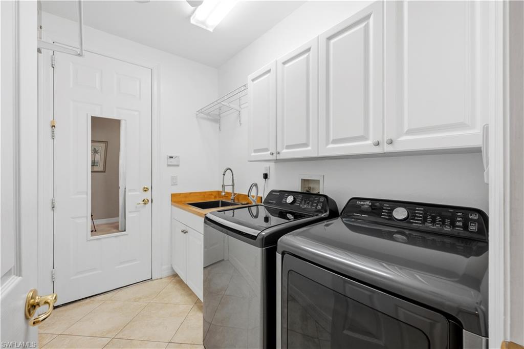 1411 Princess Sabal Point Naples, FL 34119 - Photo 18 of 32 Laundry room featuring cabinet space, light tile patterned flooring, and separate washer and dryer