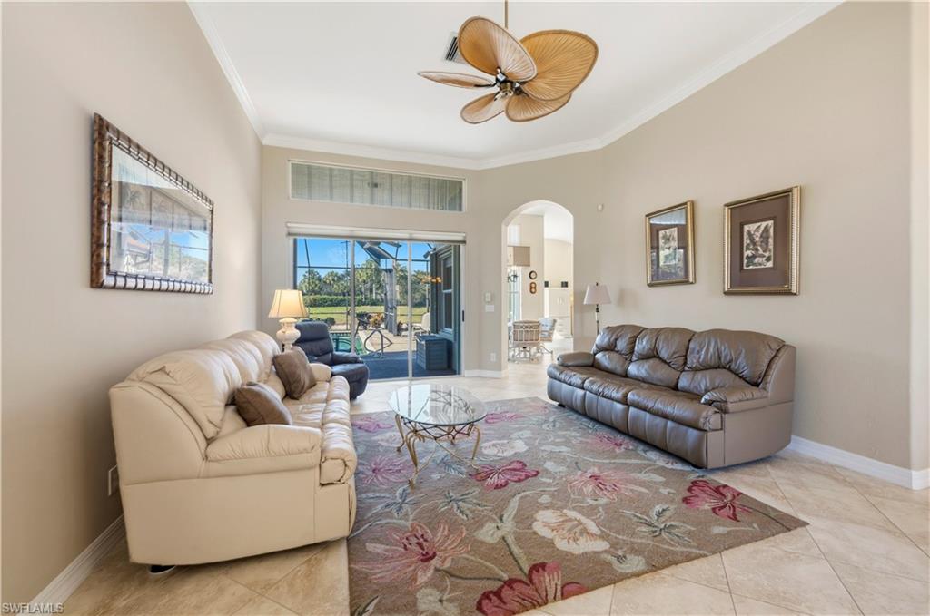 1411 Princess Sabal Point Naples, FL 34119 - Photo 4 of 32 Living room with arched walkways, a ceiling fan, a high ceiling, ornamental molding, and light tile patterned floors