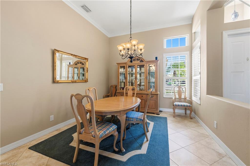 1411 Princess Sabal Point Naples, FL 34119 - Photo 5 of 31 Dining area with a chandelier, light tile patterned floors, and crown molding