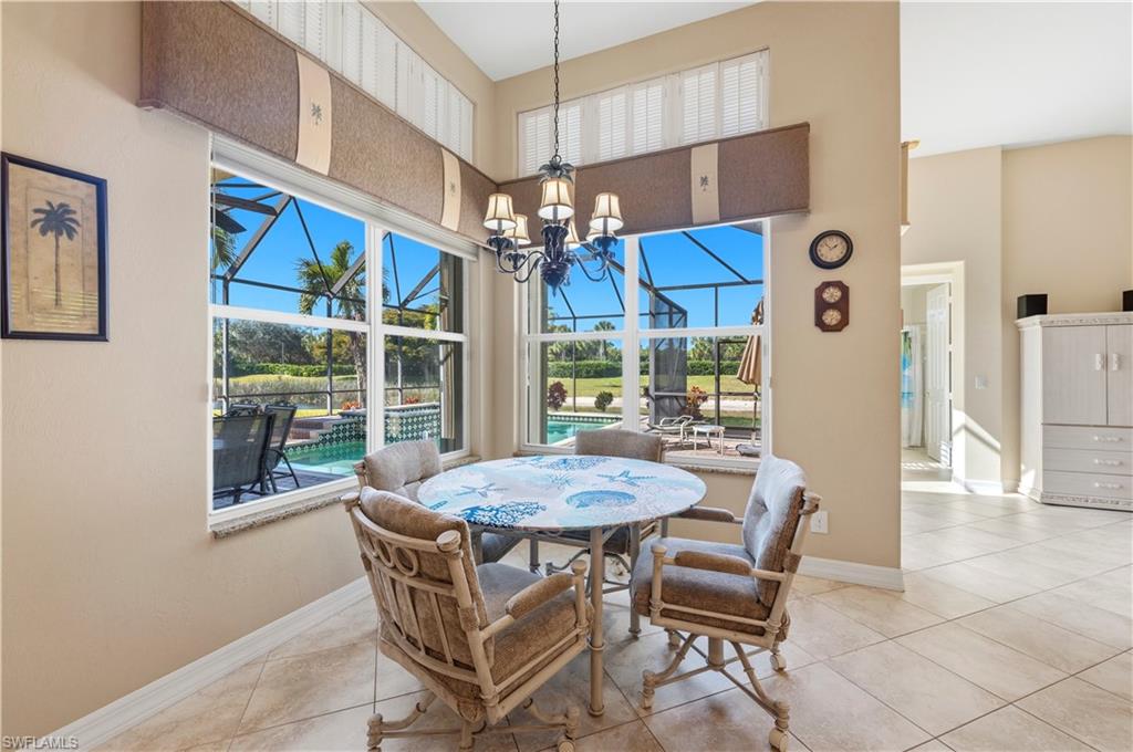 1411 Princess Sabal Point Naples, FL 34119 - Photo 7 of 30 a view of a dining room with furniture wooden floor and chandelier