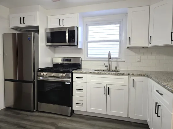 a kitchen with stainless steel appliances granite countertop a stove a refrigerator and a microwave