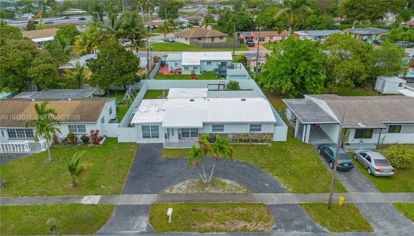 an aerial view of a house with swimming pool and outdoor seating