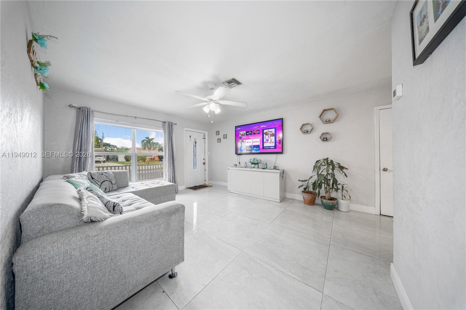 6971 Southwest 24th Street Miramar, FL 33023 - Photo 6 of 22 a living room with furniture and a flat screen tv