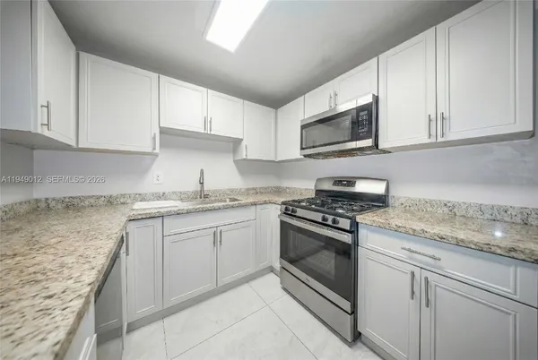 a kitchen with a refrigerator sink and cabinets