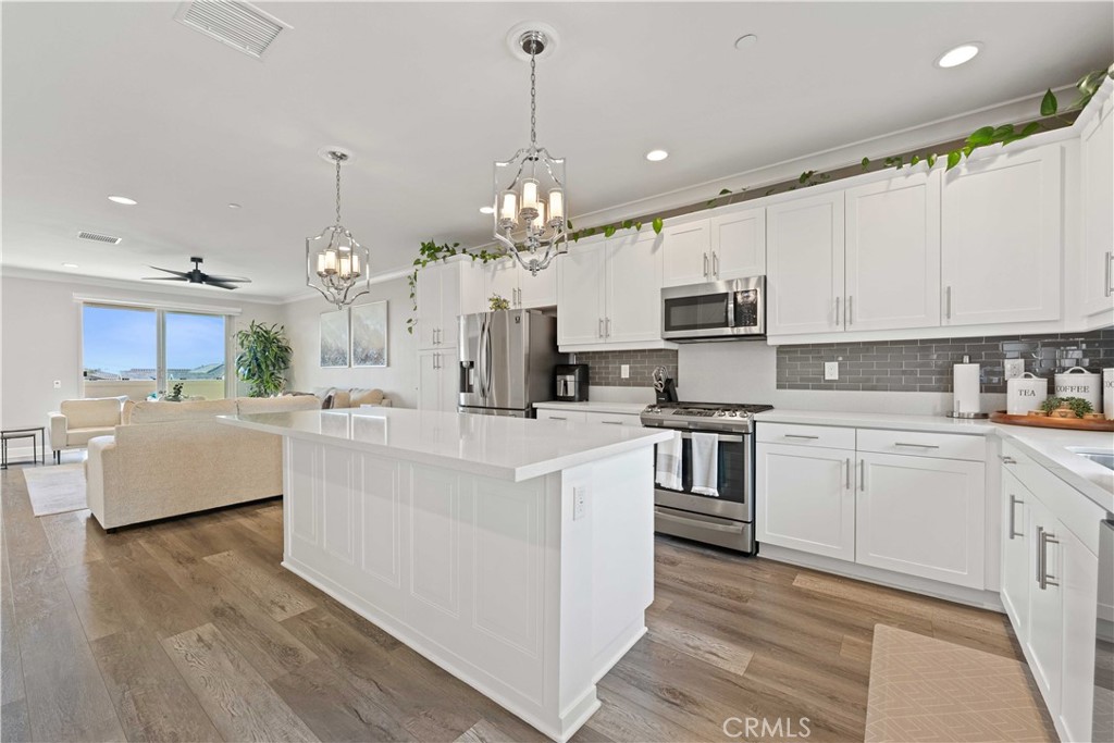 135 Alder Ridge Lake Forest, CA 92610 - Photo 13 of 30 a kitchen with kitchen island granite countertop a sink cabinets and stainless steel appliances
