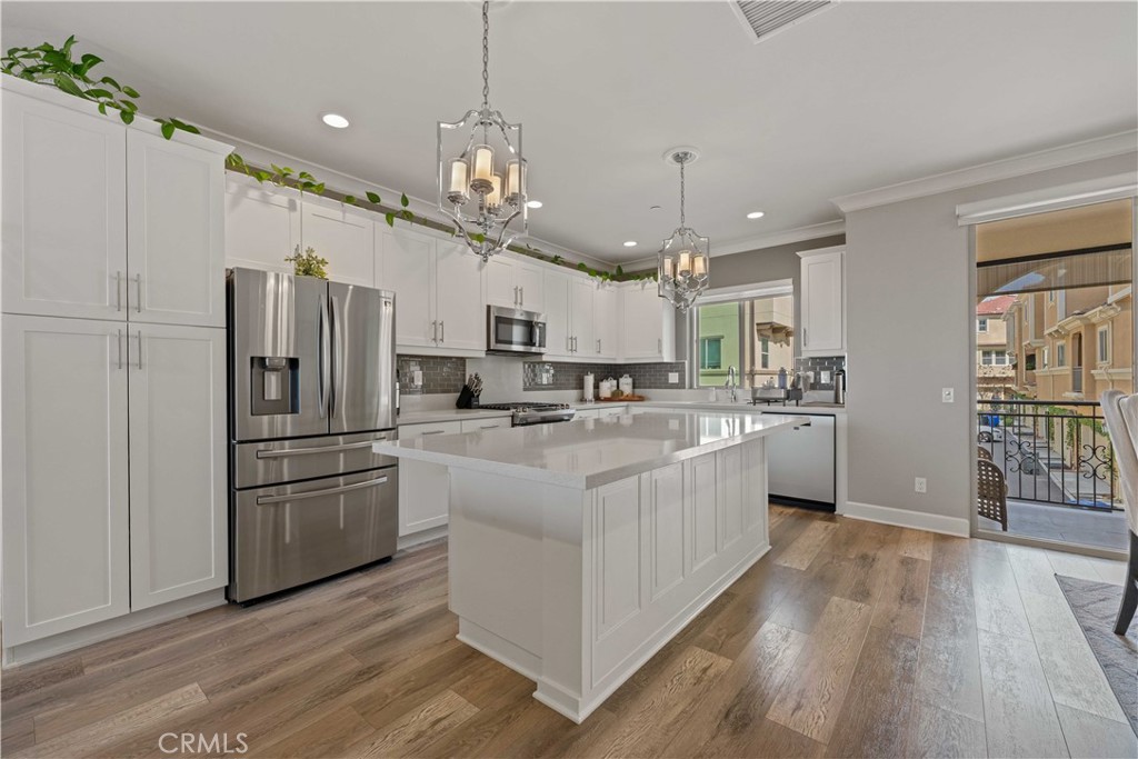 135 Alder Ridge Lake Forest, CA 92610 - Photo 8 of 30 a large kitchen with stainless steel appliances granite countertop a refrigerator a oven a island and a center island