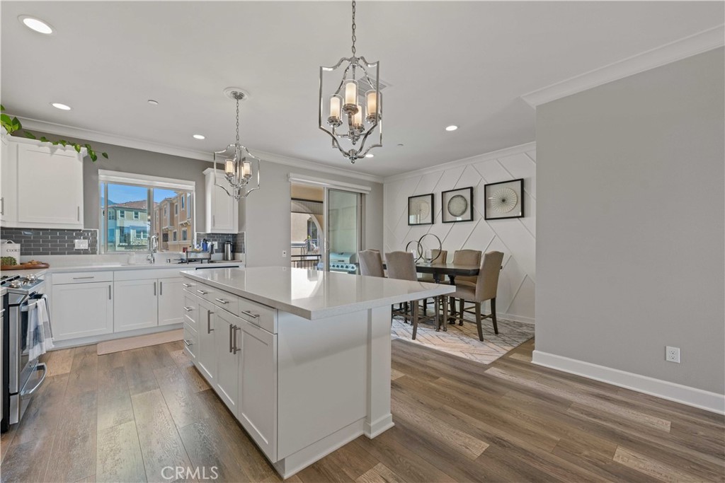 135 Alder Ridge Lake Forest, CA 92610 - Photo 9 of 30 a large white kitchen with lots of counter space and chandelier