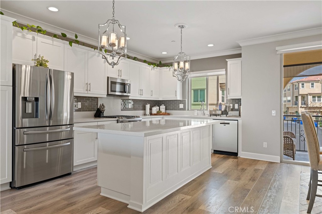 135 Alder Ridge Lake Forest, CA 92610 - Photo 10 of 30 a kitchen with kitchen island granite countertop a refrigerator a sink dishwasher a oven a large island with wooden floor and cabinets