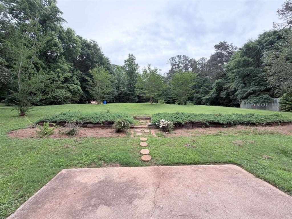 185 Roberts Road Covington, GA 30016 - Photo 21 of 25 a view of a garden with a building in the background