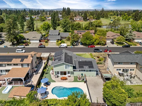 an aerial view of residential houses with outdoor space and swimming pool