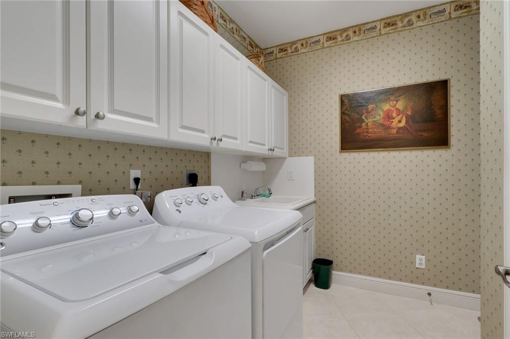 435 Terracina Way Naples, FL 34119 - Photo 29 of 50 Washroom featuring wallpapered walls, cabinet space, light tile patterned flooring, and independent washer and dryer