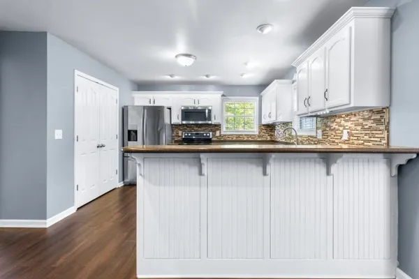 a kitchen with stainless steel appliances granite countertop a sink a stove and a refrigerator