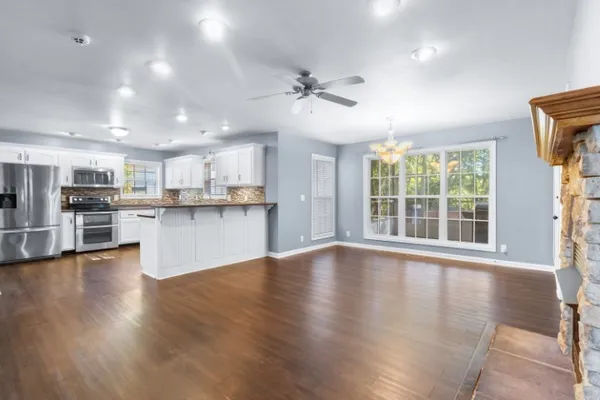 a view of kitchen with refrigerator stove and wooden floor