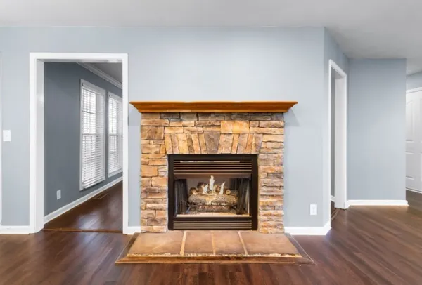 a living room with a fireplace and wooden floor