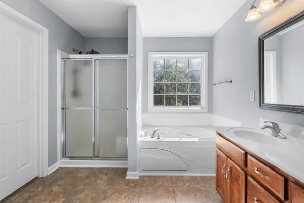 a bathroom with a tub sink and a mirror